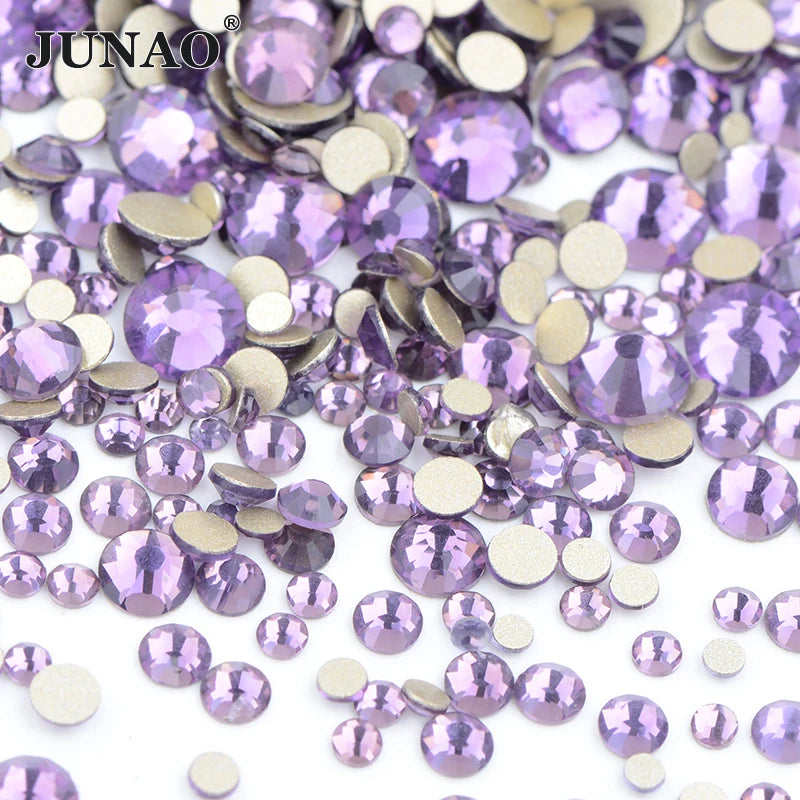 A pile of iridescent purple and silver glass rhinestones for DIY crafts