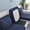 A dark blue stretch sofa seat cushion protector slipcover placed on a white sofa seat.
