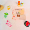 A collection of colorful iron-on embroidered patches featuring food and drink designs on a light pink background.