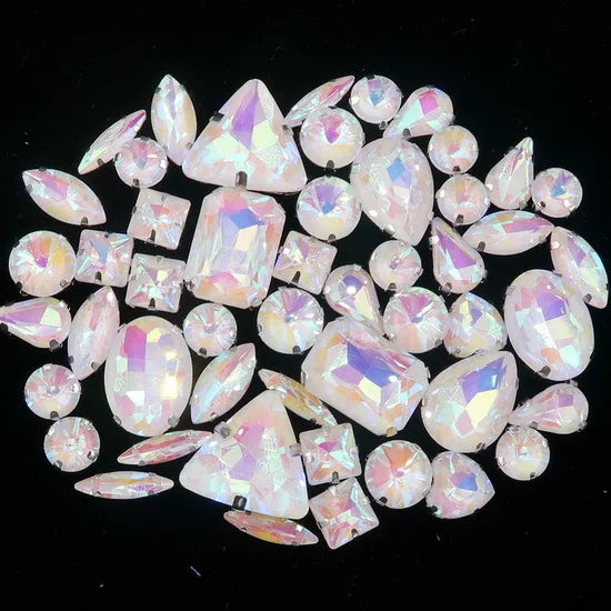 A collection of clear and iridescent silver claw rhinestones arranged in a circular pattern.