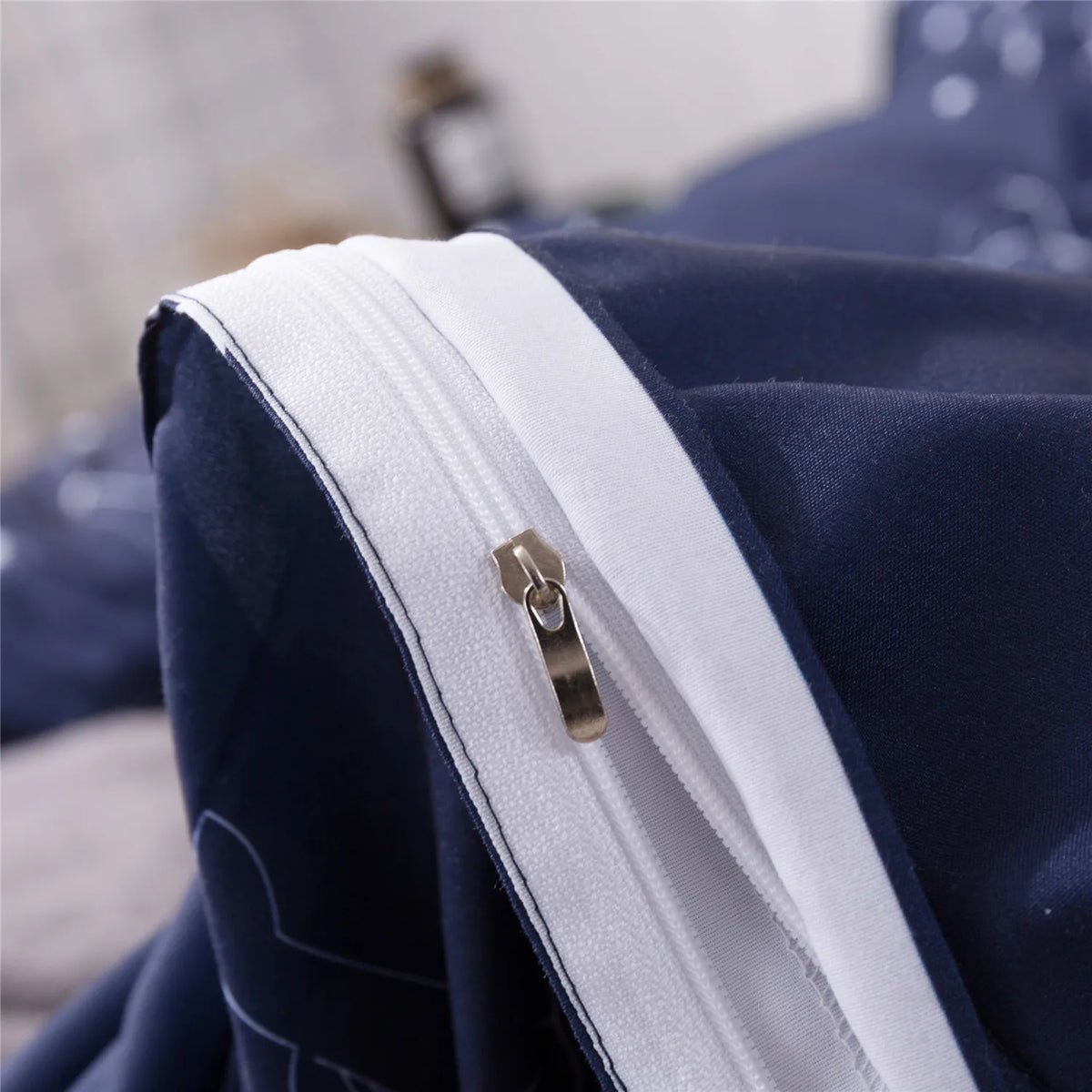 A close-up of a navy blue duvet cover with a white zipper detail.