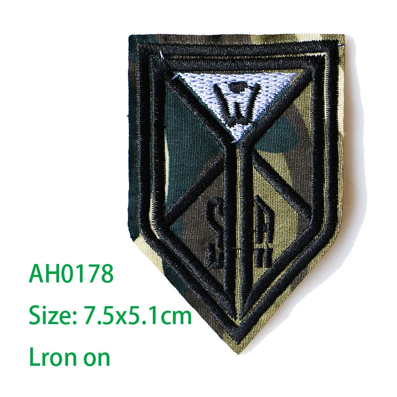 An embroidered iron-on patch featuring a dark olive background with a white triangle design and the letter W.