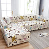 A beige sofa is covered with a stylish printed fabric featuring floral and leaf patterns on a light gray rug.