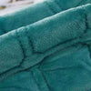 A close-up of a teal velvet quilted bedspread fabric showing the texture and stitching.