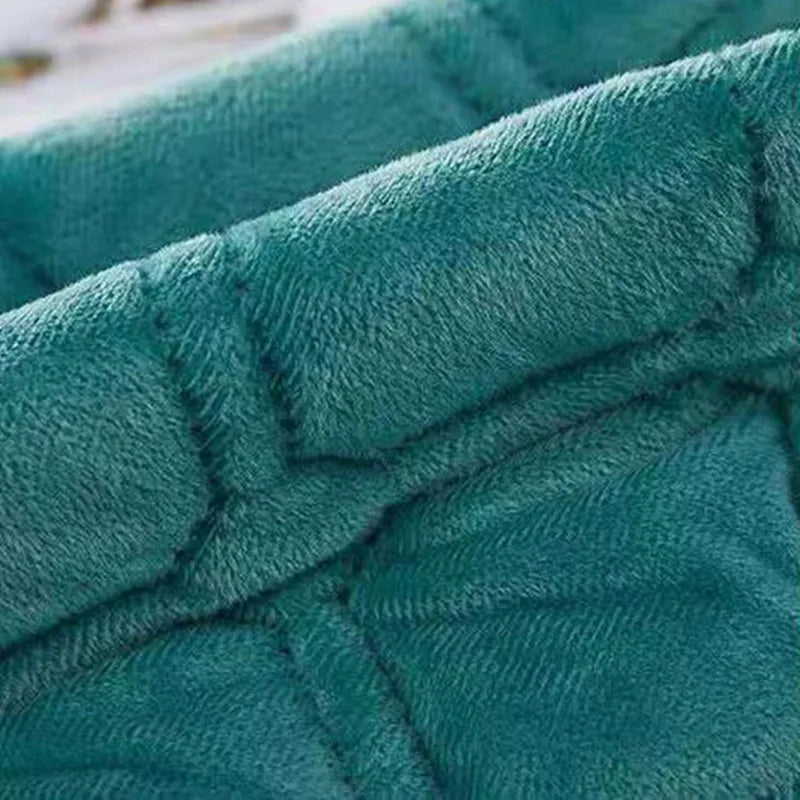 A close-up of a teal velvet quilted bedspread fabric showing the texture and stitching.