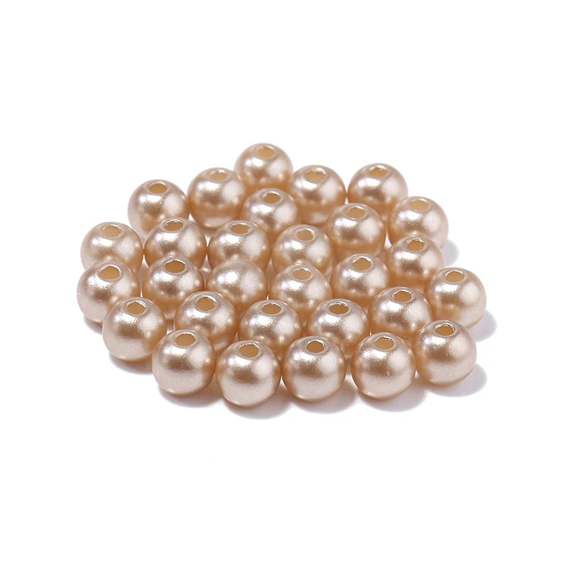 A cluster of small, round, pale pink imitation pearl beads for DIY jewelry making.