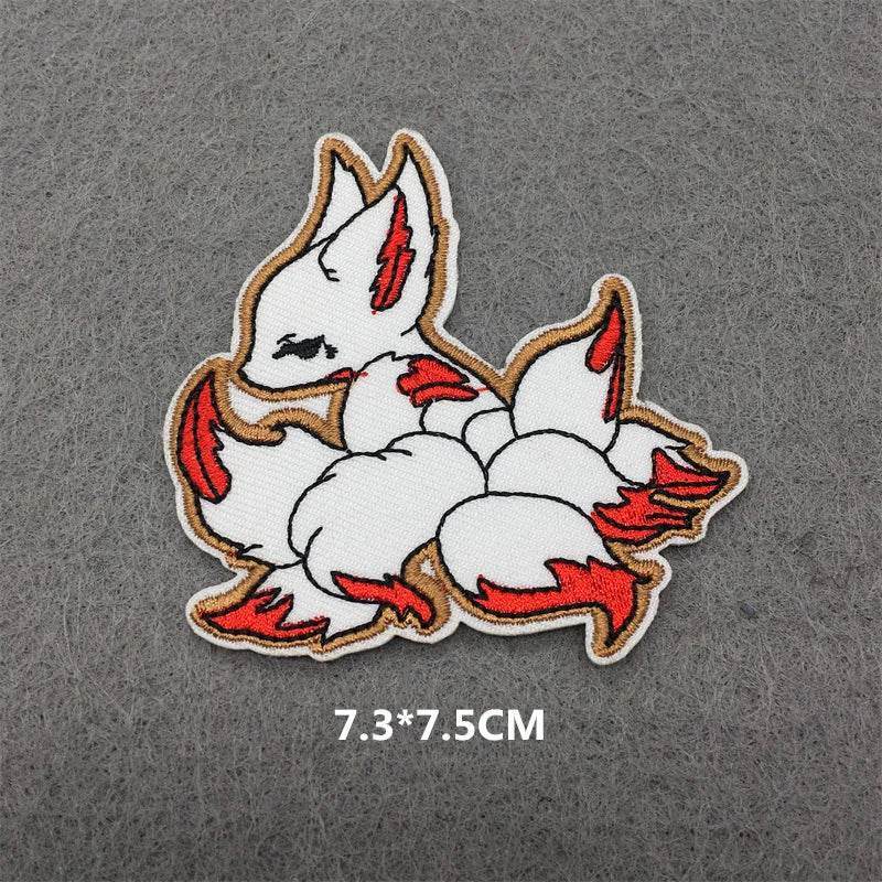 An embroidered patch featuring a white fox head with red accents on a gray background.