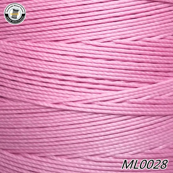 Pink waxed thread embroidery cord spool with a black and gold label