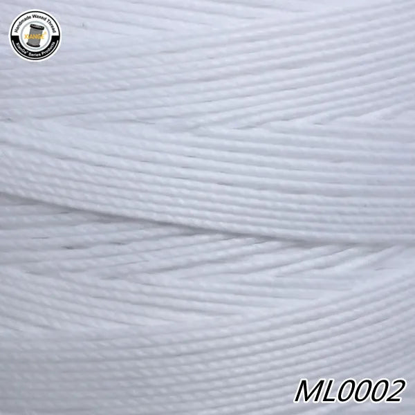 A spool of white wax thread embroidery cord is shown in a close-up view.