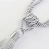 Three strands of silver rope tied together with tassels, showing the texture and knot detail.