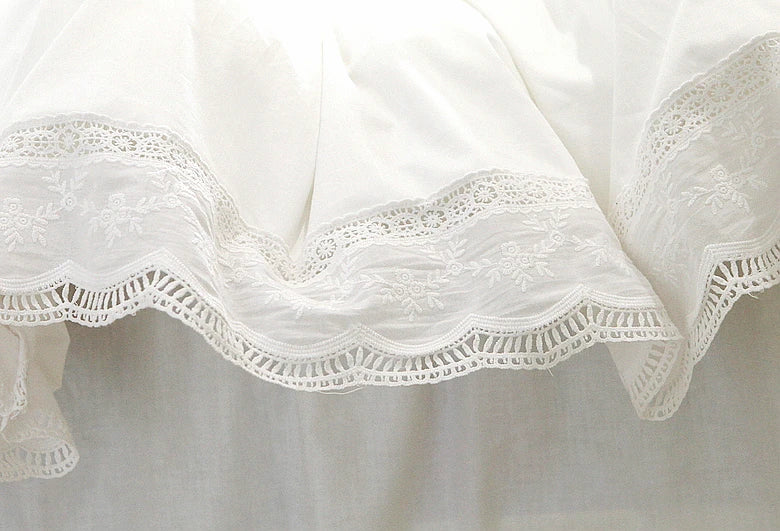 White luxury ruffle duvet cover with delicate lace trim for a king bed.