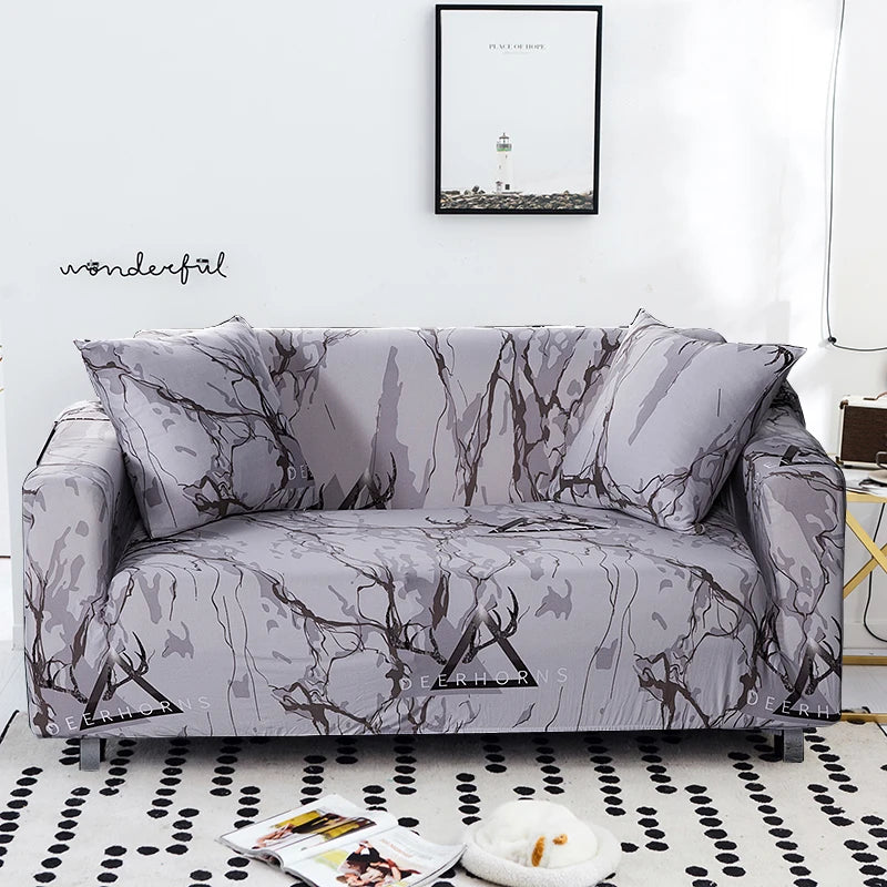 A gray sofa covered in a stretch floral elastic fabric featuring dark, abstract branch patterns.