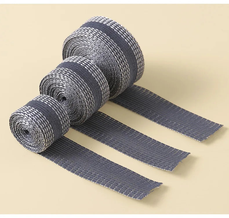 Rolls of gray self-adhesive hem tape for fabric repair and shortening displayed on a light background.