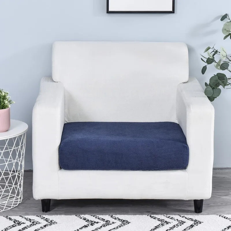 A white armchair with a dark blue stretchable fleece seat cushion cover placed on the seat.