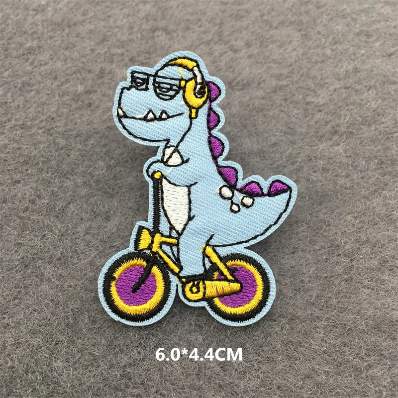 Light blue embroidered patch of a dinosaur wearing sunglasses and riding a bicycle