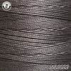 A close-up view of dark gray waxed thread embroidery cord with a label in the upper left corner.