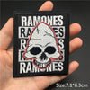 Black embroidered patch featuring a white skull design with red outline and surrounding text