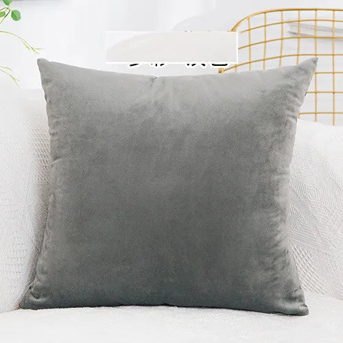 A square, solid gray velvet decorative cushion cover resting on a white surface.