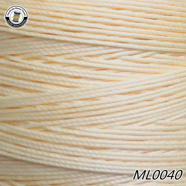 Spool of light beige waxed thread embroidery cord with a logo visible on the packaging.