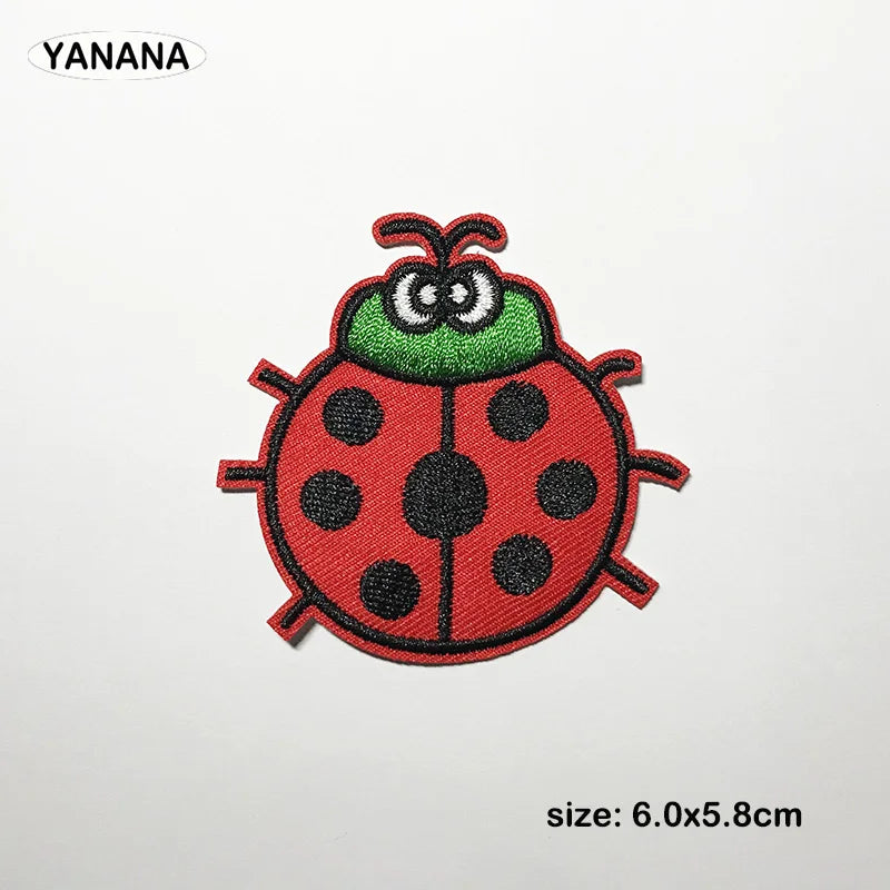 A red and green embroidered patch of a ladybug with black spots.