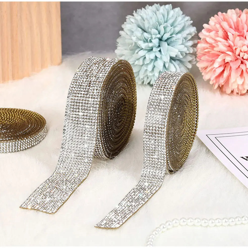Silver and gold diamond rhinestone strips for DIY decor displayed next to fluffy pom-pom flowers