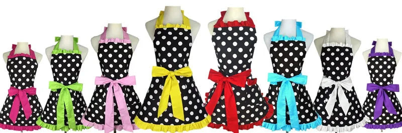 A display of various retro polka dot ruffle aprons in black and white with colorful ribbons.