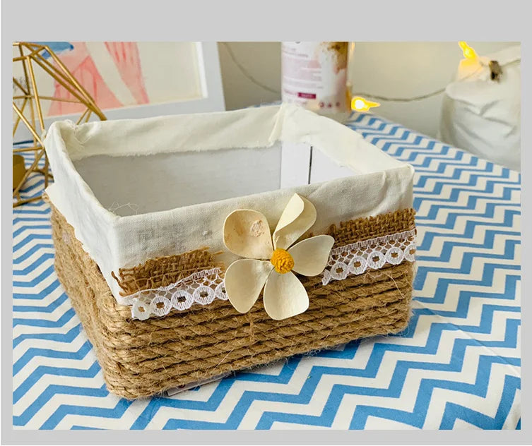 A woven jute rope basket lined with white fabric and lace, displayed on a blue and white chevron patterned cloth.