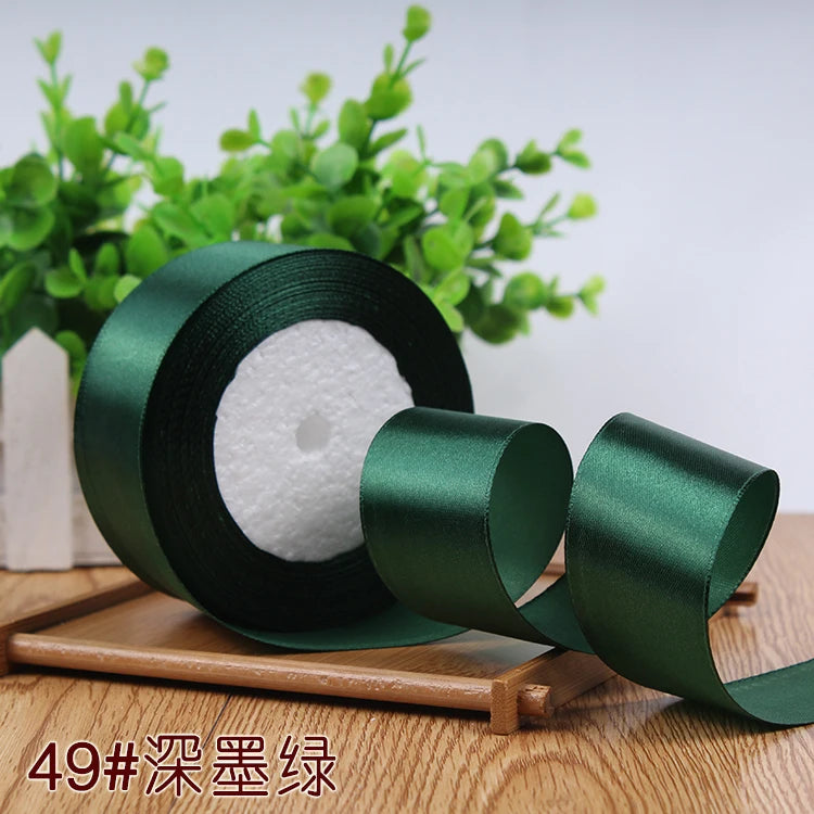 Roll of dark green satin ribbon for gift wrapping and DIY crafts