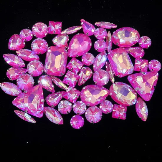 A collection of pink and magenta faceted rhinestones arranged in a decorative pattern.