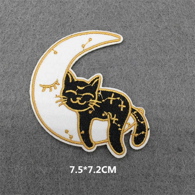 A black cat embroidered on a white crescent moon patch with gold accents.