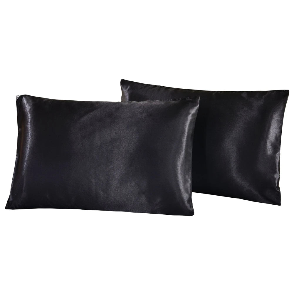 Black silky satin pillowcases stacked together.