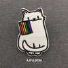 White cat embroidered patch with a rainbow flag detail on a gray felt background