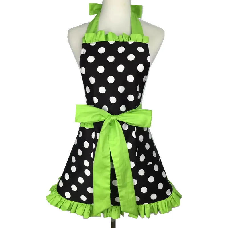 A black polka dot ruffle apron with lime green trim and pockets displayed on a mannequin.