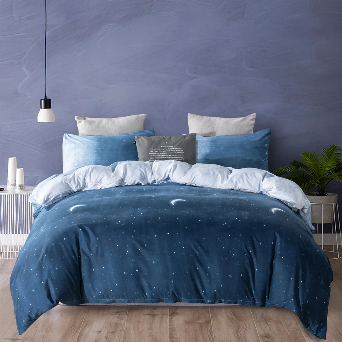 A navy blue starry sky duvet cover set displayed on a bed against a gray wall.