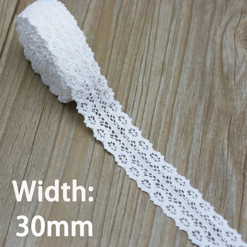 A roll of white cotton embroidered lace trim measuring 30mm wide.