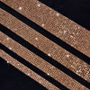 Close-up of several gold diamond rhinestone strips laid diagonally on a dark background.