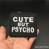 Black embroidered patch with white text Cute But Psycho
