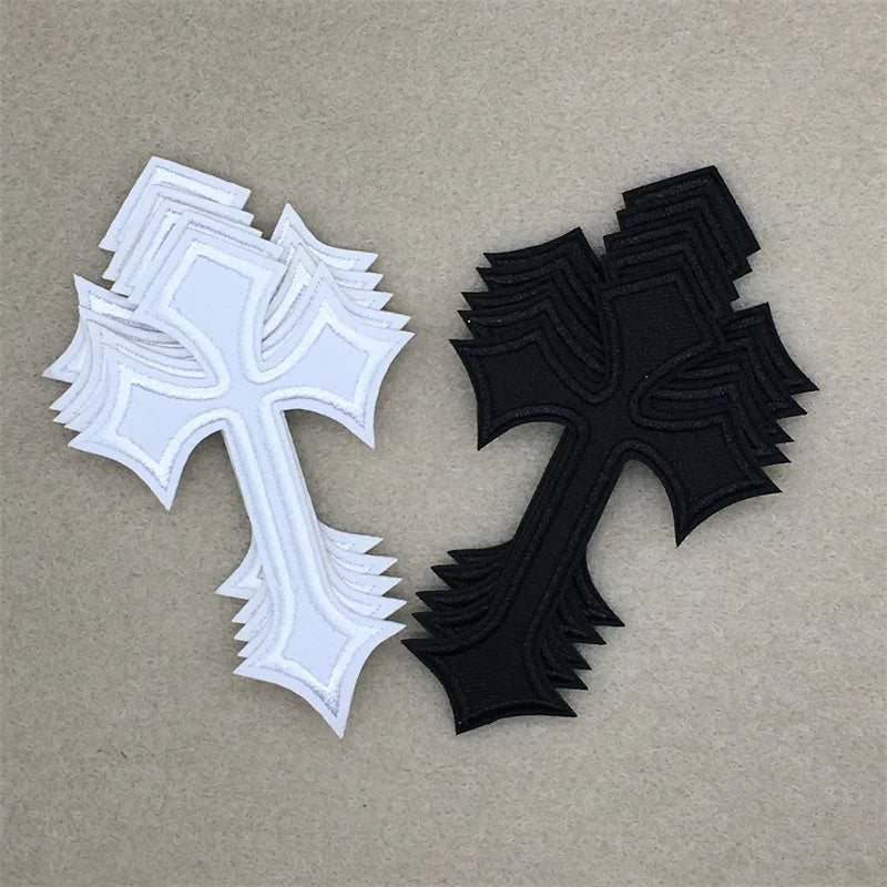 Two embroidered cross applique patches, one white and one black, displayed against a neutral background.