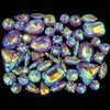 A collection of iridescent and faceted gemstone rhinestones in shades of purple, blue, and green.