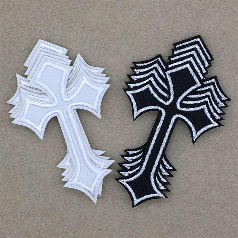 Two embroidered cross applique patches, one white and one black, displayed on a neutral background.