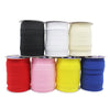 A collection of stacked bias tape binding ribbons in black, white, cream, yellow, pink, and blue.