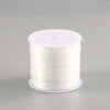 A spool of white flat elastic beading thread for jewelry making.