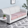 A modern white sofa with a light pink seat cushion cover and a patterned rug.