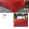 A close-up of a vibrant red crystal velvet quilted bedspread draped on a bed.
