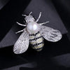Silver crystal bee brooch featuring a pearl accent and detailed wings