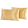 Two smooth golden satin pillowcases folded next to each other.