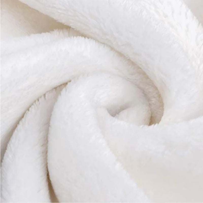 A close-up of a white retro printed flannel throw blanket rolled into a spiral.