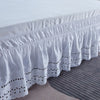 White embroidered ruffle bed skirt with scalloped edges and black eyelet detailing