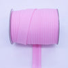 Pink durable bias tape binding ribbon rolled on a spool with a pink stick.