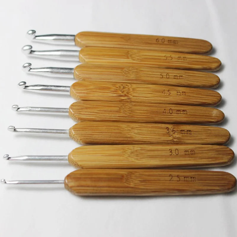 A set of bamboo crochet knitting needles with various sizes marked on the handles.
